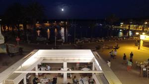 a group of people standing around a restaurant at night at Hostal S'Algaret in Fornells