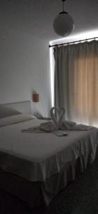 a bedroom with a bed with a curtain and a window at Hostal S'Algaret in Fornells