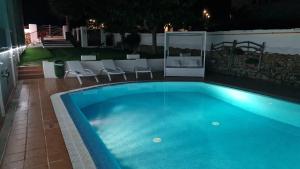 a swimming pool at night with chairs around it at Hostal S'Algaret in Fornells