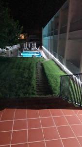 a building with a yard with a swimming pool at night at Hostal S'Algaret in Fornells