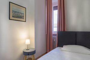 a bedroom with a bed with a lamp and a window at Suite Marco in Centro città in Verona