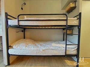 Ce lit superposé se trouve dans une chambre d'auberge de jeunesse avec des lits superposés au sol. dans l'établissement Le 313, pied de pistes La Bresse Hohneck, à La Bresse