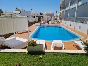 a swimming pool on the side of a building at Hostal S'Algaret in Fornells