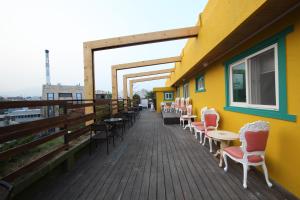 a building with chairs and tables on a deck at Calli Hostel in Busan