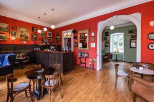 un ristorante con pareti rosse, tavoli e sedie di Burg Bernstein a Bernstein
