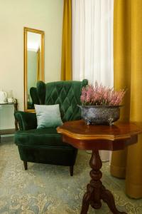 a living room with a green couch and a table at Kamienica Boutique ApartHotel in Białystok