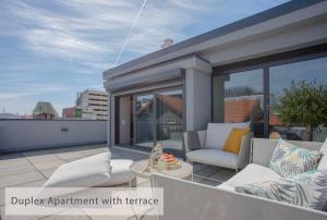 a patio with two chairs and a table on a balcony at Alegria Residence in Porto