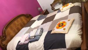 a bed with a flower pillow and towels on it at GRAZIOSO APPARTAMENTO IN ZONA SANTA RITA in Turin
