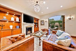 a living room with leather furniture and a fireplace at Tuscan Village Villa in San Diego