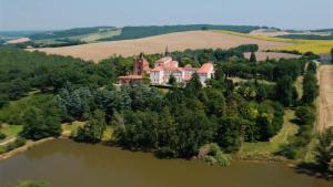 Bellegarde的住宿－Hôtellerie de l'Abbaye，湖上岛屿上房屋的空中景观