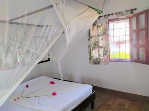1 dormitorio con cama con dosel y ventana en Karibuni Jeds Villas 85 & 86 en Mambrui