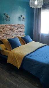 a bedroom with a large bed with blue sheets at Superbe appartement classé 4étoiles avec piscine privée in Le Boulou