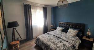 a blue bedroom with a bed and a window at Superbe appartement classé 4étoiles avec piscine privée in Le Boulou