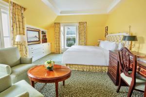 a hotel room with a bed and a table at The Lanesborough, Oetker Hotels in London