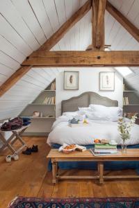 ein Schlafzimmer mit einem Bett und einem Tisch mit Büchern in der Unterkunft Le Domaine de Courances - Pierres d'Histoire in Courances