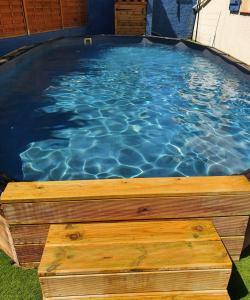 Superbe appartement classé 4étoiles avec piscine privée في لو بولو: مسبح مع كرسي خشبي في الماء