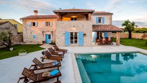 a villa with a swimming pool in front of a house at Villa Tomani by Villas Holiday in Krmed