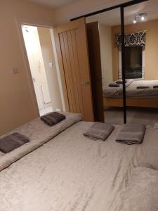 1 dormitorio con 2 camas y un espejo grande en Church Street Apartments en Inverness