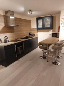 a kitchen with a wooden table and a wooden floor at Church Street Apartments in Inverness