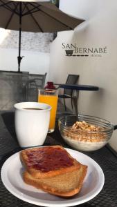 una mesa con un plato de tostadas y un tazón de zumo de naranja en Hostal San Bernabé en Guanajuato