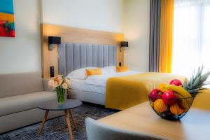 pokój hotelowy z łóżkiem i miską owoców na stole w obiekcie Bešeňová Gino Paradise Apartments with Aquapark w Beszeniowej