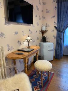 a desk with a lamp and a chair in a room at Hôtel du Lion d'Or in Cauterets