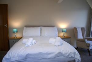 a bedroom with a white bed with towels on it at Riverside 3 in Dartmouth