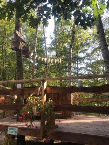 une clôture en bois avec un portail et une table fleurie dans l'établissement Domek na Drzewie!, à Rudka Gołębska