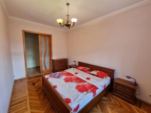 ein Schlafzimmer mit einem Bett mit roten Blumen darauf in der Unterkunft Grand Ultracentral Apartments Stefan cel Mare in the heart of Chisinau in Chişinău