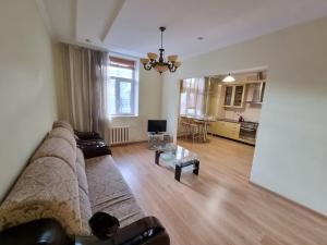 ein Wohnzimmer mit einem Sofa und einem Tisch in der Unterkunft Grand Ultracentral Apartments Stefan cel Mare in the heart of Chisinau in Chişinău