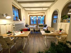 a living room with tables and chairs and a dining room at Hotel Kranenborgh Steinhude am Meer in Steinhude