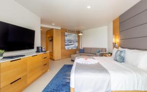 
a hotel room with a bed and a television at The Morgan Resort Spa & Village in Simpson Bay
