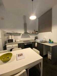 a kitchen with a white table and a white counter top at Esparteria 2 in Barcelona