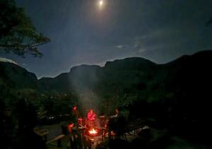 a group of people sitting around a fire at night at Refúgio Ecológico Pedra Afiada in Praia Grande