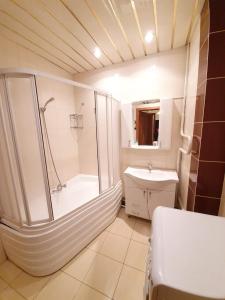 uma casa de banho com um chuveiro, uma banheira e um lavatório. em Stefan cel Mare Boulevard Ultracentral Apartments in the Center Chisinau em Chisinau