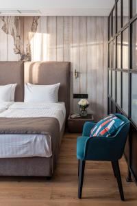 a bedroom with a bed and a blue chair at Loft7 in Lviv