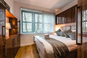 a bedroom with a large bed and a large window at Bishopsgate House in Coventry