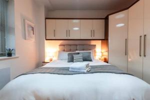 a bedroom with a large white bed with white cabinets at Bishopsgate House in Coventry