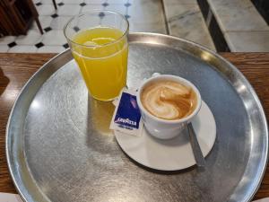 a plate with a glass of orange juice and a cup of coffee at Hostal S'Algaret in Fornells