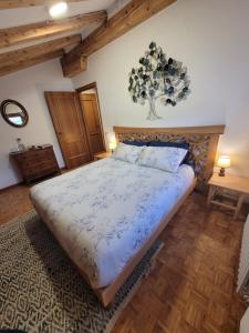 a bedroom with a bed with a blue and white comforter at B&B I FAGGI in Lavarone