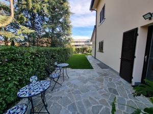 a patio with two chairs and two tables at B&B Villa Eden in Vimercate