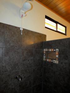 a bathroom with a shower with a shower head at Tapiru's House - Bahia Drake in Drake