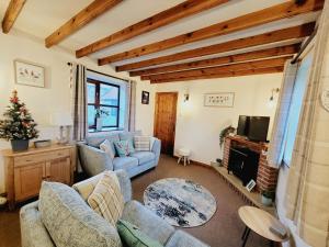 uma sala de estar com dois sofás e uma televisão em Grosmont Cottage, Ruswarp em Whitby