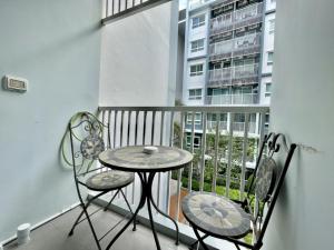 a balcony with a table and chairs on a balcony at The trust huahin resort condo greeny room in Hua Hin
