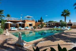 een zwembad met een standbeeld voor een huis bij Serena Villa in Ibiza-stad