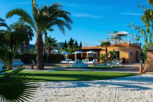 una casa en la playa con palmeras en Serena Villa en Ibiza