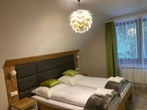 1 dormitorio con cama y lámpara de araña en Leśna Polana, en Radawa