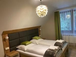 a bedroom with a bed and a chandelier at Leśna Polana in Radawa