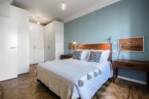 een slaapkamer met een groot bed en een blauwe muur bij Casas da Tapada in Lissabon