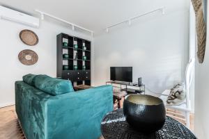 a living room with a blue couch and a television at Casas da Tapada in Lisbon